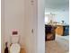 Bathroom with a toilet in the foreground, with a glimpse of the living room and kitchen at 12239 Fawn Brindle St, Riverview, FL 33578