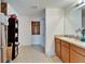 Bathroom with a double sink vanity, tiled floors, and a decorative glass window on a door at 12239 Fawn Brindle St, Riverview, FL 33578