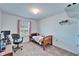 Cozy carpeted bedroom with a wooden bed frame, a window with blinds, and a desk for studying or working at 12239 Fawn Brindle St, Riverview, FL 33578