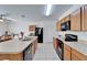 Modern kitchen featuring wooden cabinets, black appliances, a large island, and tile flooring at 12239 Fawn Brindle St, Riverview, FL 33578