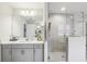 Bright bathroom featuring a shower, tile floor, and a double sink with gray cabinets at 12829 Tortoise Shell Pl, Riverview, FL 33579