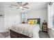 Cozy bedroom featuring a ceiling fan, wood floors, large windows, and tropical accents at 12829 Tortoise Shell Pl, Riverview, FL 33579