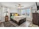 Comfortable bedroom with a ceiling fan, wood floors, large windows, and tropical accents at 12829 Tortoise Shell Pl, Riverview, FL 33579