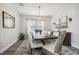 Bright dining room with a large table, white chairs, modern chandelier, and neutral décor at 12829 Tortoise Shell Pl, Riverview, FL 33579