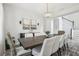 Modern dining room with a large table, white chairs, elegant lighting, and access to the staircase at 12829 Tortoise Shell Pl, Riverview, FL 33579