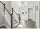 Bright foyer with wood-look tile, staircase with wooden banister, and front door with decorative wreath at 12829 Tortoise Shell Pl, Riverview, FL 33579