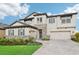 Inviting two-story home with stone accents, neutral siding, shutters, manicured lawn, and two-car garage at 12829 Tortoise Shell Pl, Riverview, FL 33579