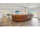 Open-concept living room with wood-look floors, leather sectional couch, and access to a private lanai at 12829 Tortoise Shell Pl, Riverview, FL 33579