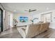 Bright living room with a large sectional sofa, wood-look flooring, a ceiling fan, and a large sliding glass door at 12829 Tortoise Shell Pl, Riverview, FL 33579