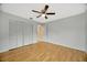 Bright bedroom featuring hardwood floors, a ceiling fan, and a spacious closet at 13128 Hazelcrest St, Spring Hill, FL 34609