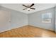 A neutral bedroom featuring hardwood floors, a fan and window views at 13128 Hazelcrest St, Spring Hill, FL 34609