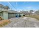 View of a house's side with garage, driveway, and expansive yard space at 13128 Hazelcrest St, Spring Hill, FL 34609