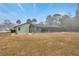 Backyard view of a home with screened in pool and mature trees at 13128 Hazelcrest St, Spring Hill, FL 34609