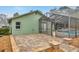 Rear exterior view of the home with a screened-in pool, brick-paved patio, and verdant landscaping at 13128 Hazelcrest St, Spring Hill, FL 34609