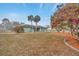 Landscaped front yard with flowers and palm trees at 13128 Hazelcrest St, Spring Hill, FL 34609