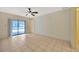 Living room with tiled flooring, ceiling fan, and sliding glass door to the pool at 13128 Hazelcrest St, Spring Hill, FL 34609