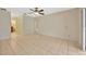 Open-concept living room featuring neutral tile flooring and a ceiling fan at 13128 Hazelcrest St, Spring Hill, FL 34609