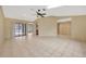 Spacious living room featuring tile floors, a ceiling fan, and access to the lanai at 13128 Hazelcrest St, Spring Hill, FL 34609