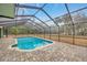 Beautiful screened-in pool area with brick pavers and a clear view of the surrounding landscaped backyard at 13128 Hazelcrest St, Spring Hill, FL 34609