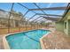 Well-maintained screened pool area featuring a brick-paved deck and clear views of the backyard at 13128 Hazelcrest St, Spring Hill, FL 34609