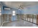 Blue bedroom with terrazzo floors, back door access, and window AC unit at 13313 2Nd E St, Madeira Beach, FL 33708