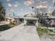 A single-story home featuring a carport, palm trees, and a concrete driveway at 13313 2Nd E St, Madeira Beach, FL 33708