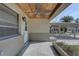 Charming front porch showcasing a wooden ceiling, fan, and entry door at 13313 2Nd E St, Madeira Beach, FL 33708