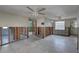 Spacious living room with exposed block walls, ceiling fan and natural light at 13313 2Nd E St, Madeira Beach, FL 33708