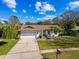 Beautiful aerial view of a home with mature landscaping, lush lawn and a wide driveway at 15109 Winterwind Dr, Tampa, FL 33624