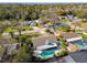 Aerial view of a home featuring a private pool, well-maintained landscaping, and serene neighborhood at 15109 Winterwind Dr, Tampa, FL 33624