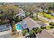 Aerial view of a residence showcasing the pool, patio, and surrounding lush landscaping and neighborhood at 15109 Winterwind Dr, Tampa, FL 33624