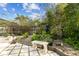 Cozy backyard with a stone bench surrounded by lush greenery, perfect for relaxation at 15109 Winterwind Dr, Tampa, FL 33624