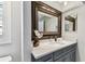 Bathroom featuring vanity with stone countertop, under-mount sink and large framed mirror at 15109 Winterwind Dr, Tampa, FL 33624