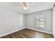 Bedroom with wood-look floors, neutral walls, ceiling fan and bright window at 15109 Winterwind Dr, Tampa, FL 33624