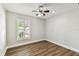 Bright bedroom featuring wood floors, a ceiling fan and a window with plantation shutters at 15109 Winterwind Dr, Tampa, FL 33624