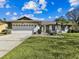 Charming home exterior featuring a well-maintained lawn, beautiful fountain and a two-car garage at 15109 Winterwind Dr, Tampa, FL 33624