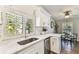 Bright kitchen with white cabinets, stainless steel sink, and window with shutters at 15109 Winterwind Dr, Tampa, FL 33624