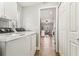 Functional laundry room featuring modern appliances, white cabinets, and natural light at 15109 Winterwind Dr, Tampa, FL 33624