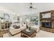 Cozy living room with stone fireplace, ceiling fan, and view of the patio at 15109 Winterwind Dr, Tampa, FL 33624