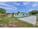 Rear exterior view of the home featuring an adjacent shed and a tall fence for privacy at 1530 Clair Mel Cir, Tampa, FL 33619