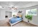 Serene bedroom showcasing carpet flooring, a ceiling fan, and ample natural light from surrounding windows at 1530 Clair Mel Cir, Tampa, FL 33619