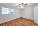 This bedroom features wood floors, a ceiling fan, and a window with natural light at 1530 Clair Mel Cir, Tampa, FL 33619