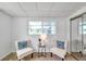 Bright bedroom nook featuring two comfy chairs, a small table, and a large window for ample sunlight at 1530 Clair Mel Cir, Tampa, FL 33619