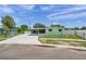 Exterior view of the property with a fenced yard, long driveway, and a charming, light-green color at 1530 Clair Mel Cir, Tampa, FL 33619