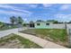 Exterior view of the property with a fenced yard, long driveway, and a charming, light-green color at 1530 Clair Mel Cir, Tampa, FL 33619