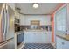 Well-lit kitchen featuring white cabinetry, stainless steel appliances, and a blue accent rug at 18675 Us Highway 19 N # 320, Clearwater, FL 33764