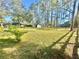 Large backyard featuring green grass with some buildings in the distance at 18840 Rustic Woods Trl, Odessa, FL 33556