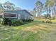 Exterior view of home with mature landscaping and screened in porch at 18840 Rustic Woods Trl, Odessa, FL 33556