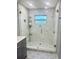 Modern glass-enclosed shower features sleek tiling and a decorative patterned floor at 18840 Rustic Woods Trl, Odessa, FL 33556