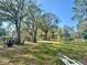 Wide, grassy backyard with a chicken coop and plenty of room for recreation and relaxation at 18840 Rustic Woods Trl, Odessa, FL 33556